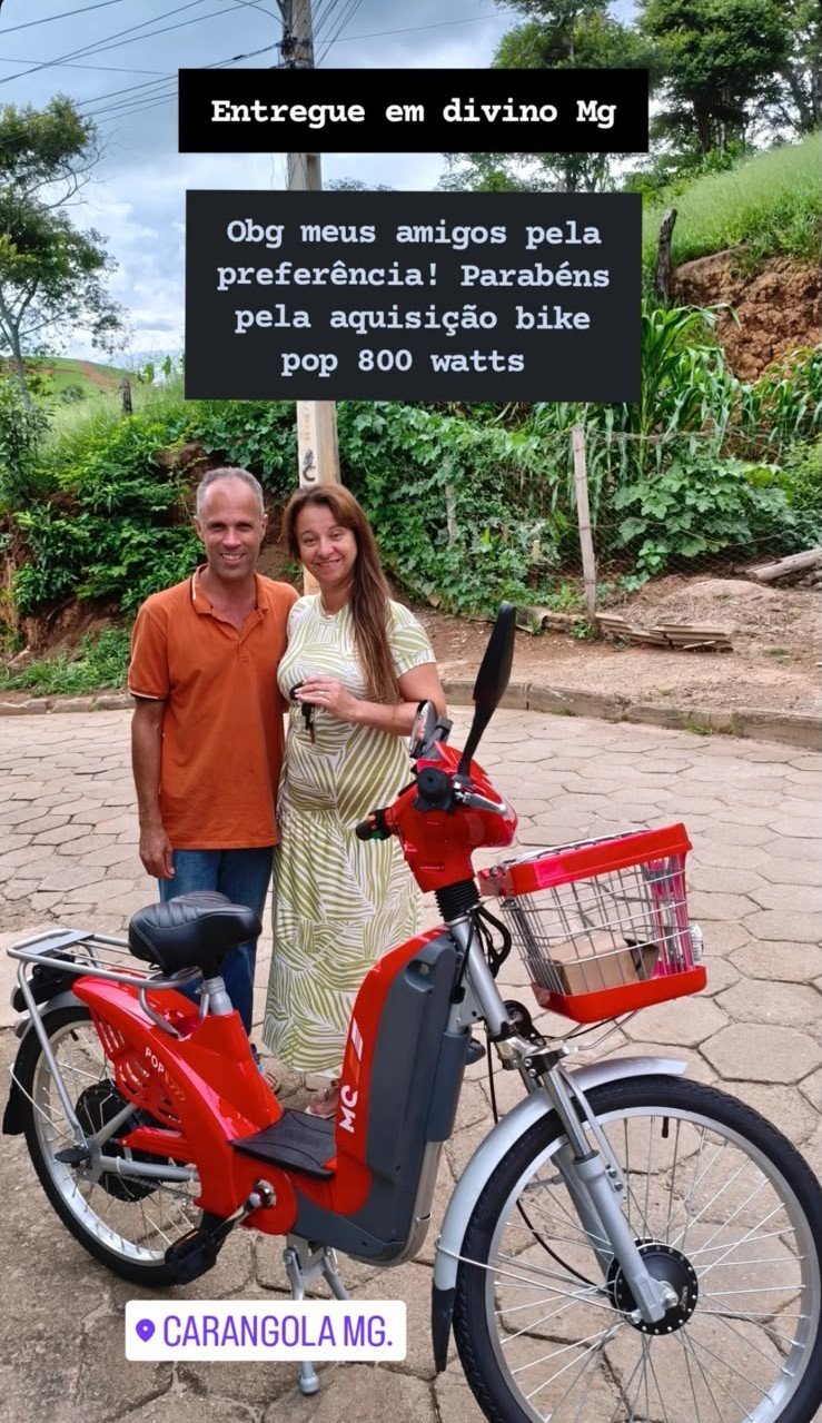 Entrega de uma Bike Pop elétrica vermelha a clientes em Divino, Minas Gerais